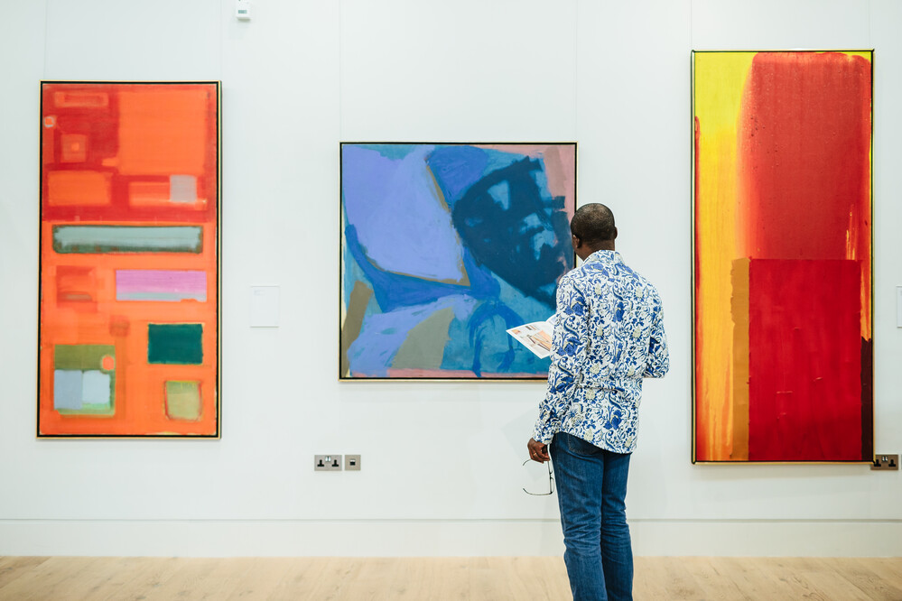 Person looking at three modern art paintings in the Stanley and Audrey Burton gallery